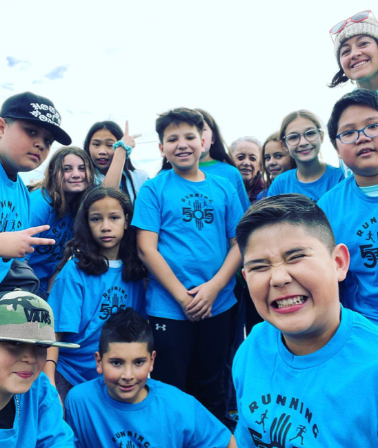 Running 505 kids in blue shirts smiling