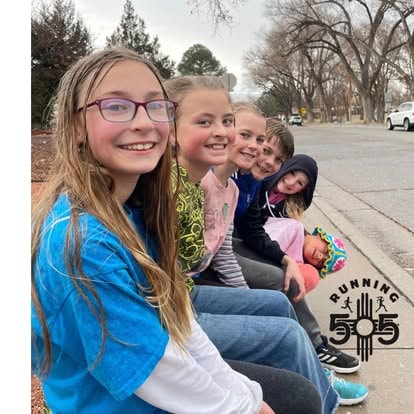 Running 505 girls sitting together on a curb after a run