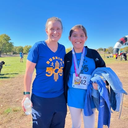 Running 505 mentor with young athlete at finish line